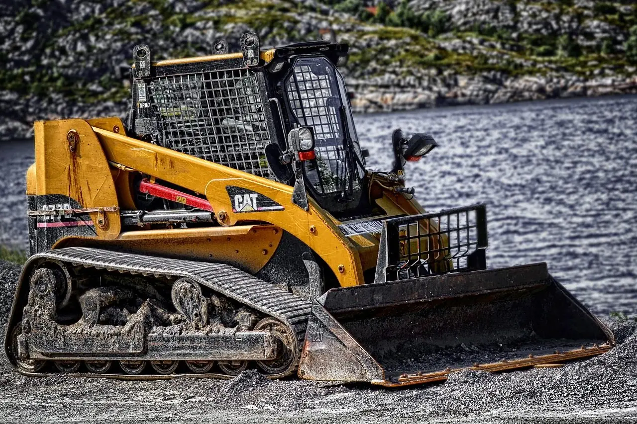 Yellow compact track loader with a bucket on a gravel lot